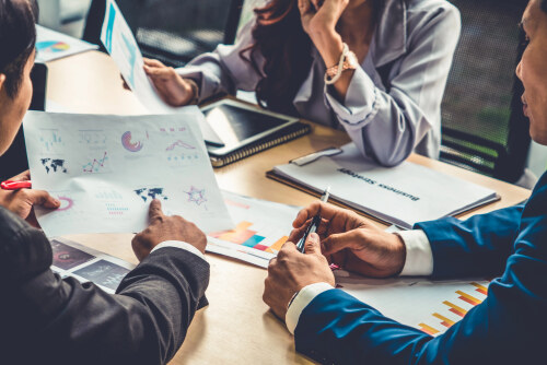Smart businessman and businesswoman talking discussion in group meeting at office table in a modern office interior. Business collaboration strategic planning and brainstorming of coworkers.